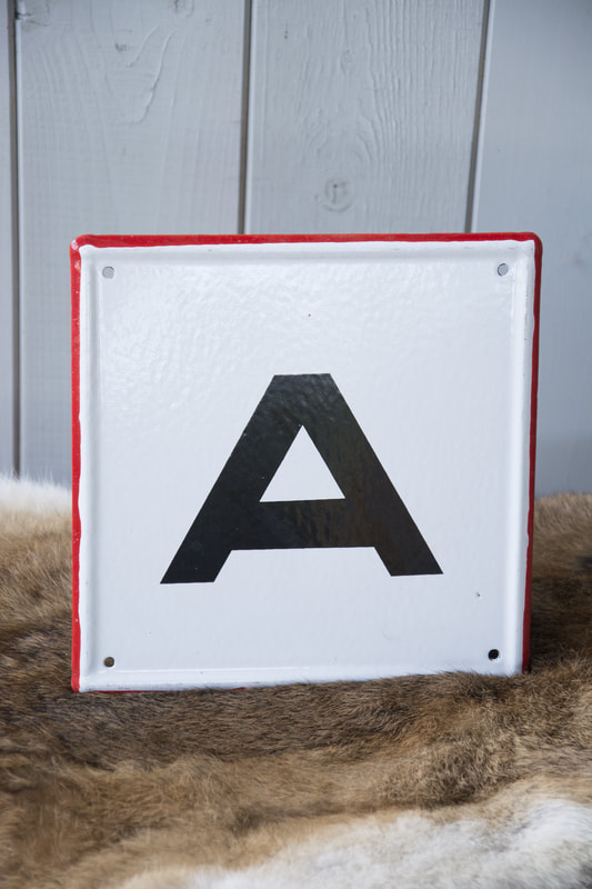Wit emaillen bord met rode rand en letter A