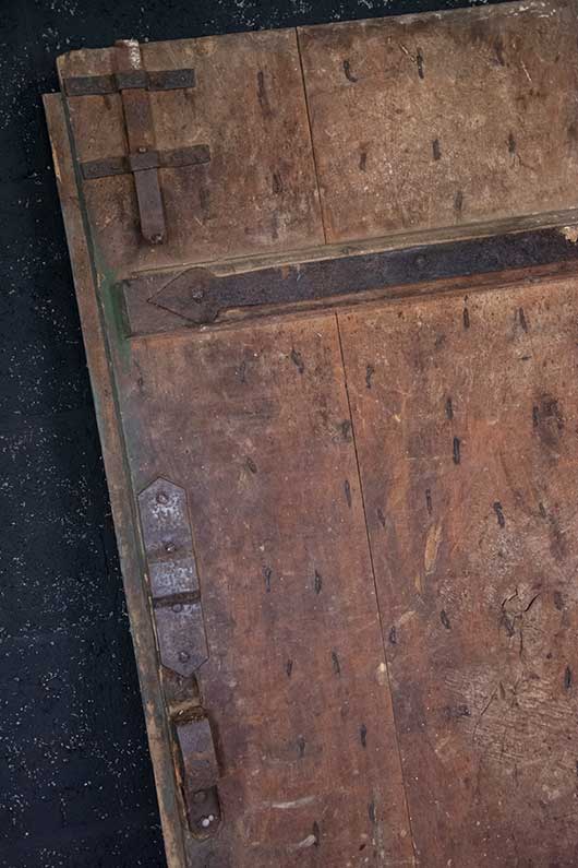 Antieke deur met houtsnijwerk en metalen hang- en sluitwerk