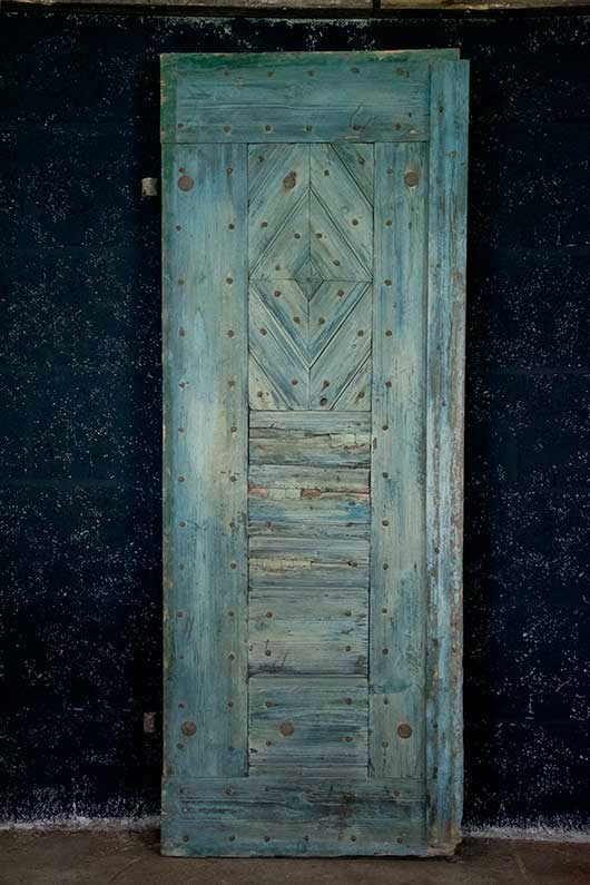 Oude deur met houtsnijwerk en metalen hang- en sluitwerk